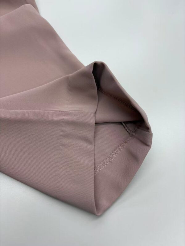 Close-up of taupe dress fabric showing smooth texture and neat stitching, ideal for fashion and clothing design.