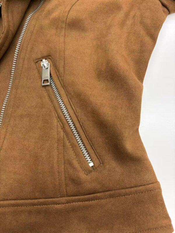 Close-up of a brown leather jacket with a silver zipper pocket, showcasing high-quality craftsmanship and trendy fashion style.