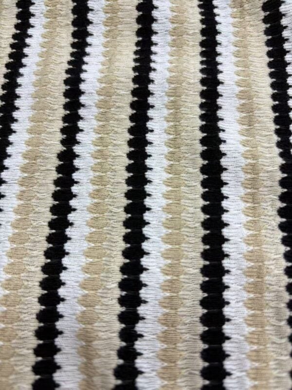 Close-up of striped knit fabric featuring black, white, and beige colors, showcasing textured pattern suitable for clothing and accessories.