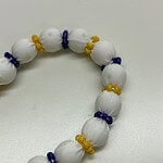 Colorful handmade beaded necklace featuring white fabric beads with blue and yellow accents, perfect for stylish accessories.