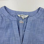 Close-up of a blue checkered women's shirt with a round neckline and button closure, suitable for casual or office wear.