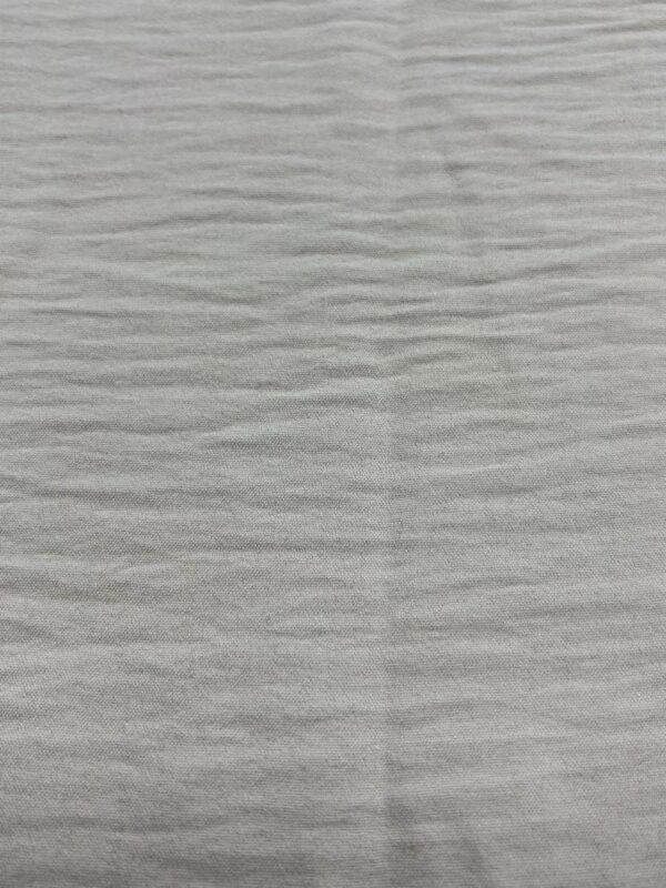 Close-up of a light gray wooden surface with subtle grain texture, ideal for fashion product displays or background settings.