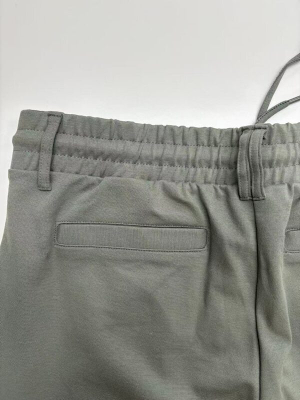 Close-up of gray casual pants with elastic waistband and back pocket, suitable for everyday wear and comfortable fashion.