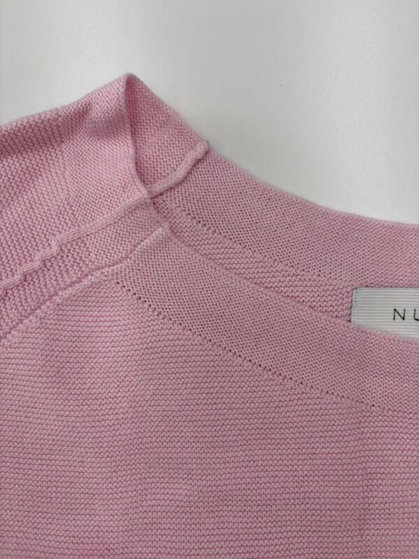 Close-up of a pink knitted sweater showing the neckline and fabric texture, ideal for women's fashion and casual wear.