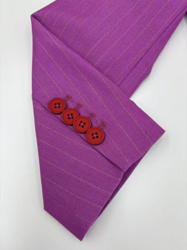 Close-up of a purple suit sleeve with subtle pinstripes and four red buttons, showcasing stylish tailoring and vibrant color for fashion enthusiasts.