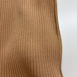 Close-up of a tan ribbed knit dress showing vertical lines and soft texture, perfect for casual or elegant wear.