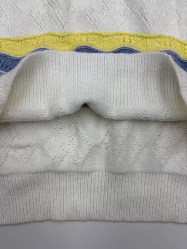 Detailed view of white fabric with colorful yellow and blue stripes, showcasing texture and stitching details.