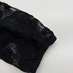 Close-up of a black lace sleeve showcasing intricate floral patterns and delicate fabric, perfect for fashion and clothing design.
