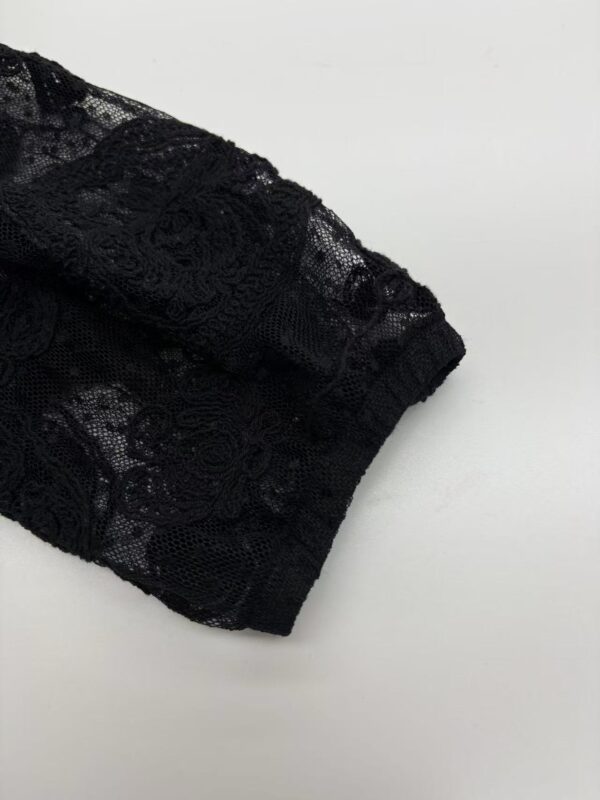 Close-up of a black lace sleeve showcasing intricate floral patterns and delicate fabric, perfect for fashion and clothing design.
