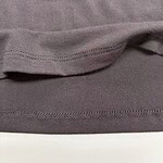 Detailed close-up of fabric hem showing stitching and texture, highlighting quality and craftsmanship of clothing from nbfish-fashion.com.
