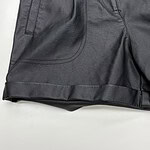 Close-up of stylish black leather shorts with detailed stitching and design, perfect for modern fashion and streetwear looks.