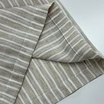 Close-up of beige striped linen fabric, showcasing its texture and pattern, ideal for fashion and home decor projects.