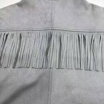 Close-up of a gray western-style jacket with fringe detailing across the back yoke, made of soft fabric, showcasing a stylish and casual fashion piece.