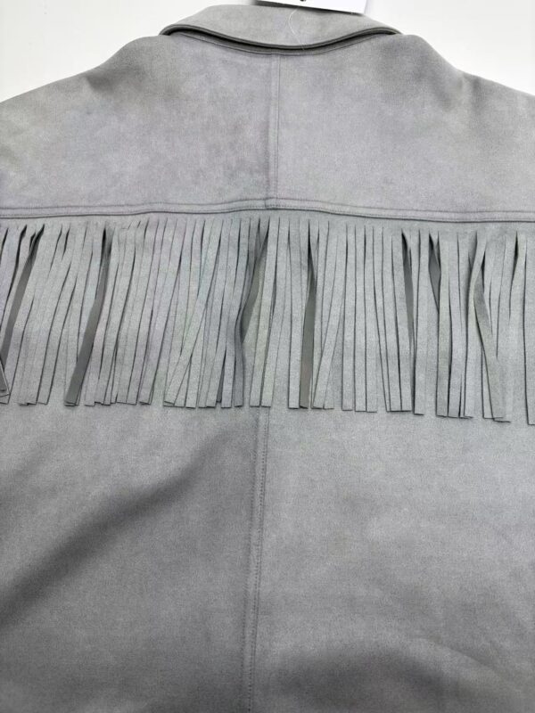 Close-up of a gray western-style jacket with fringe detailing across the back yoke, made of soft fabric, showcasing a stylish and casual fashion piece.