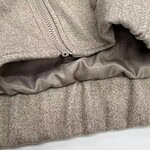 Close-up of a grey hoodie featuring a zipper and soft fabric, ideal for casual wear and comfortable fashion.