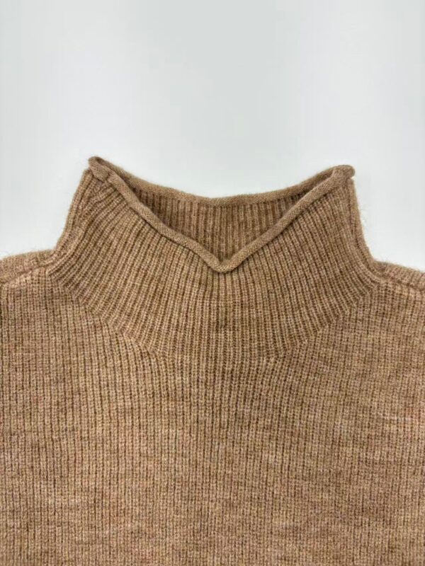 Close-up of a brown knitted turtleneck sweater, showcasing its texture and design, perfect for fall and winter fashion.