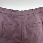 Close-up of mauve dress pants with belt loops and back pockets, suitable for formal or business wear.
