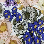 Close-up of a floral fabric pattern featuring pink, white, purple, and blue flowers with green leaves, ideal for fashion and textile projects.