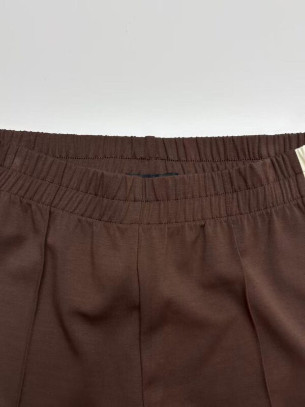 Close-up of brown casual pants with elastic waistband, suitable for everyday wear and comfortable fit.