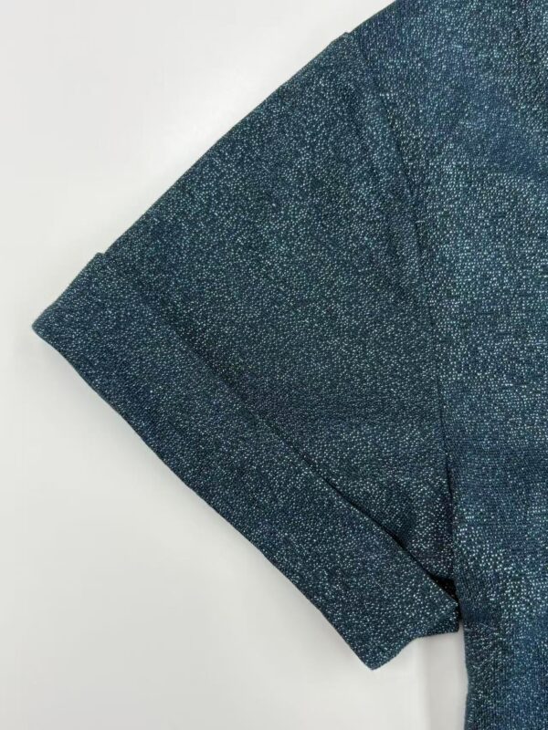 Close-up of a blue blazer with a subtle sparkle effect, showcasing the fabric texture and tailored sleeve design, perfect for fashionable office wear or evening outings.