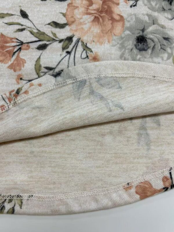 Close-up of floral fabric featuring pastel-colored flowers and soft, lightweight material suitable for fashion or home decor.