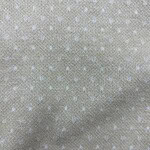 Close-up of beige fabric with small white polka dots, ideal for stylish clothing and accessories.