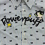 Close-up of a blue and white striped shirt featuring Powerpuff Girls character and logo, with small bow patterns and a playful design.