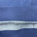 Close-up image of a blue knitted fabric with textured stripes, showcasing the detailed stitching and material quality.
