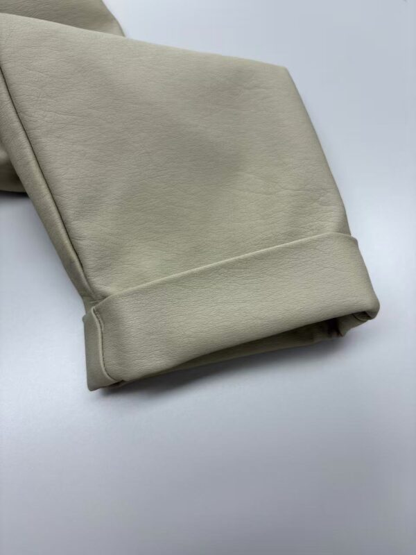 Close-up of beige leather fabric, showcasing smooth texture and high-quality material suitable for fashion and apparel projects.