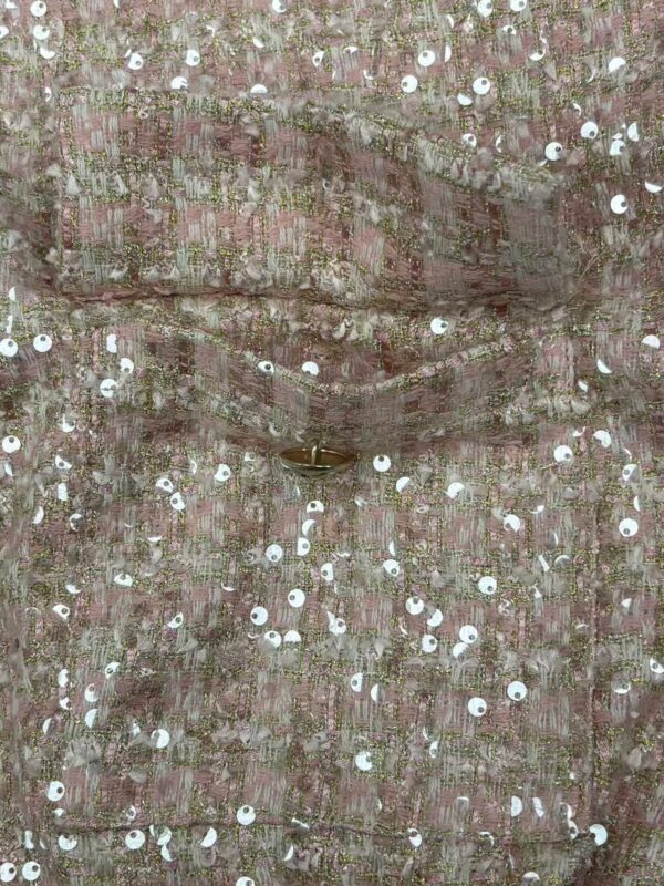 Close-up of a pink sequin dress with intricate embroidery and shiny sequins, perfect for special occasions and parties.