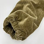 Close-up of a brown velvet sleeve with elastic cuff, showcasing soft texture and luxurious fabric for fashion and clothing design.