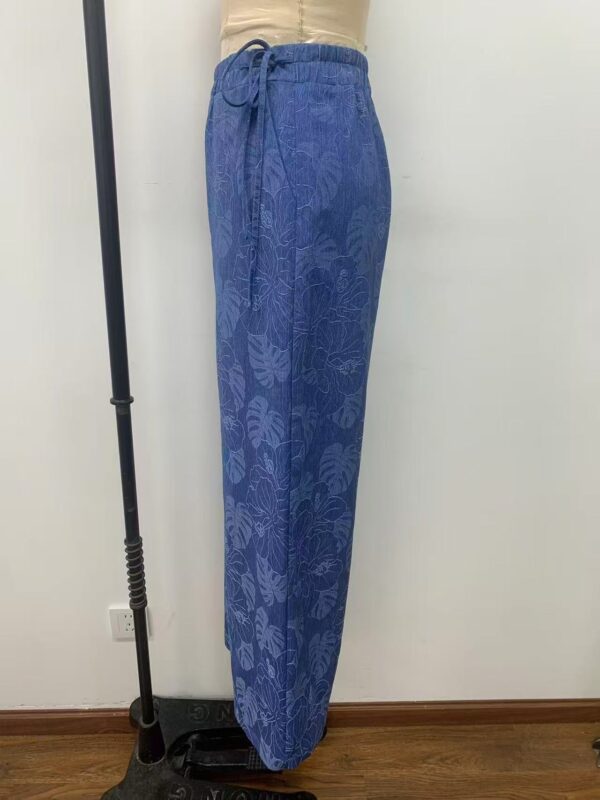 Comfortable blue lounge pants with tropical leaf print, featuring an elastic waistband with a drawstring, perfect for casual wear or relaxing at home.