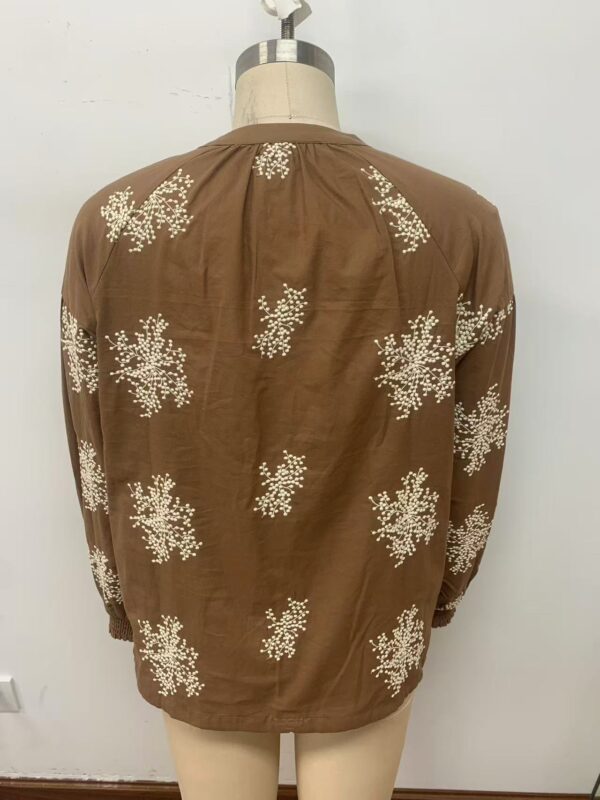 Elegant brown blouse with white floral embroidery, perfect for casual or semi-formal occasions, showcasing stylish and comfortable fashion.