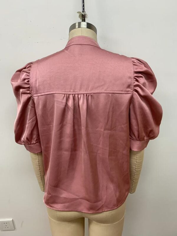 Pink women's blouse with puff sleeves and classic design, perfect for casual or formal wear, displayed on a mannequin.