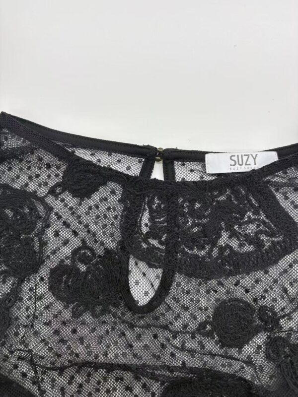 Close-up of a black lace top with floral patterns, featuring a keyhole neckline and delicate embroidery, perfect for stylish evening wear.