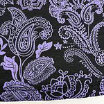 Close-up of a black fabric with intricate purple paisley and floral patterns, showcasing detailed embroidery suitable for fashion and textile design.