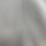 Close-up of smooth, light gray fabric with subtle texture, ideal for fashion and upholstery design.