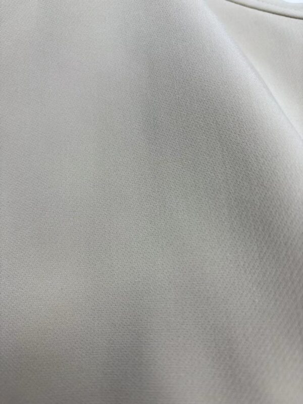 Close-up of smooth, light gray fabric with subtle texture, ideal for fashion and upholstery design.