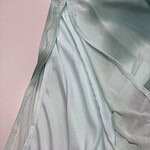 Close-up of luxurious mint green satin fabric with smooth texture and subtle sheen, perfect for high-end fashion and evening wear.