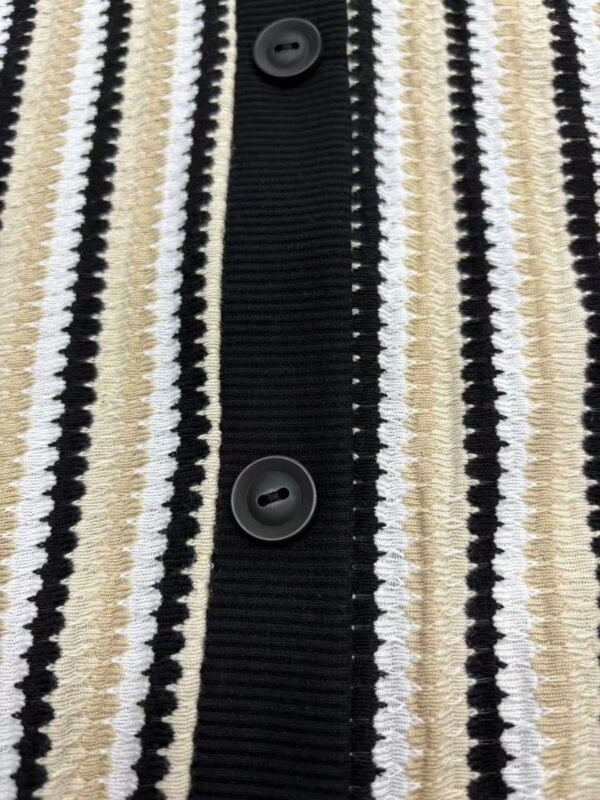 Close-up of a women's striped knit cardigan featuring black, white, and beige vertical lines with black buttons.