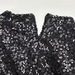 Close-up of black sequin fabric with shiny, reflective sequins for stylish clothing and accessories.