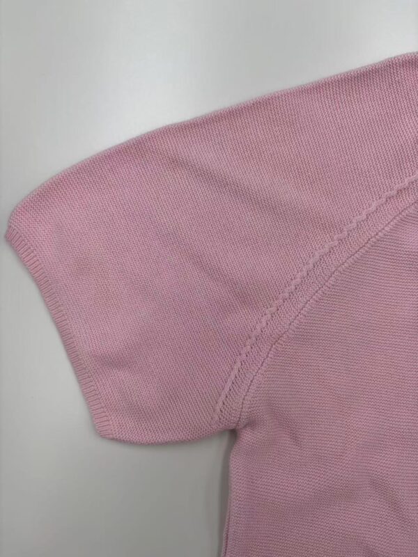 Close-up of a pink women's T-shirt showing fabric texture and stitching details.