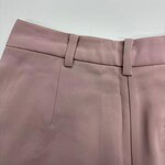 Close-up of stylish pink dress pants with belt loops, tailored fit, and smooth fabric, ideal for office or formal occasions.