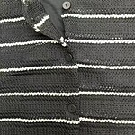 Close-up of a black and white striped knitted cardigan with buttons, perfect for casual or office wear.