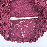 Close-up of a pink floral lace dress with intricate embroidery and sheer fabric details, perfect for special occasions.