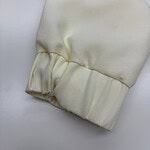 Close-up of a cream-colored fabric sleeve featuring an elastic cuff, showcasing smooth texture and neat stitching, ideal for fashion or clothing product display.