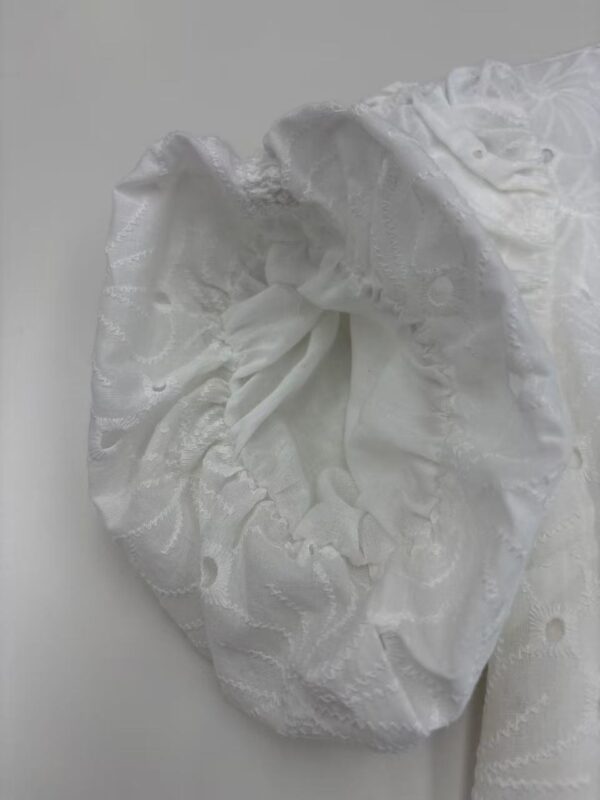 Close-up of a white lace hair bonnet with ruffled edges, ideal for hair protection and styling.