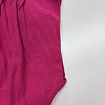 Close-up of vibrant pink velvet pants with pleats, showcasing soft texture and stylish design, perfect for fashionable women's wardrobe.