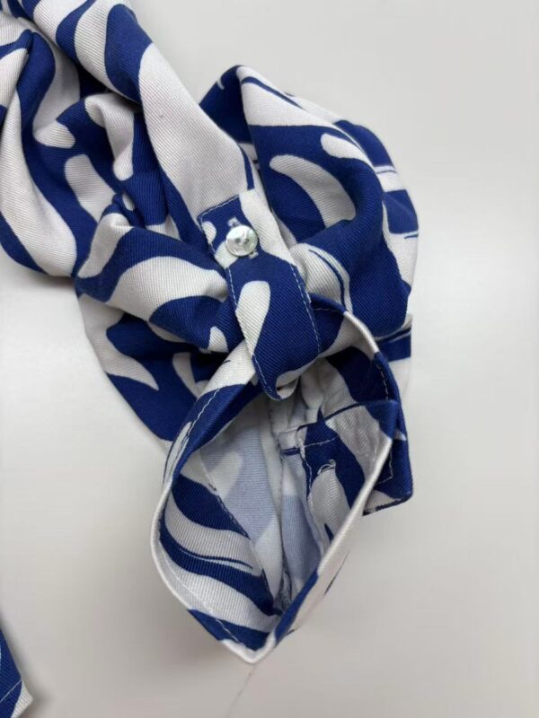Stylish blue and white patterned scarf with a knot, perfect for adding a fashionable touch to any outfit.