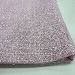 Close-up of pink textured fabric with a subtle shimmer, showcasing fine weave and luxurious appearance, ideal for fashion and upholstery.